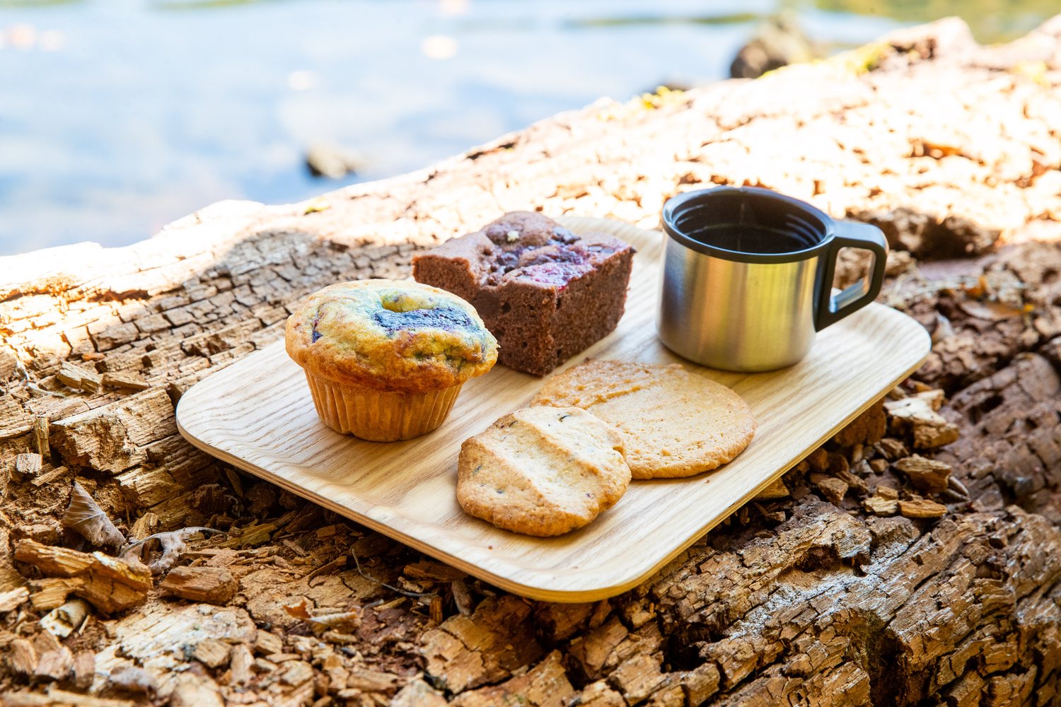 Trail snacks and coffee on a log by the water