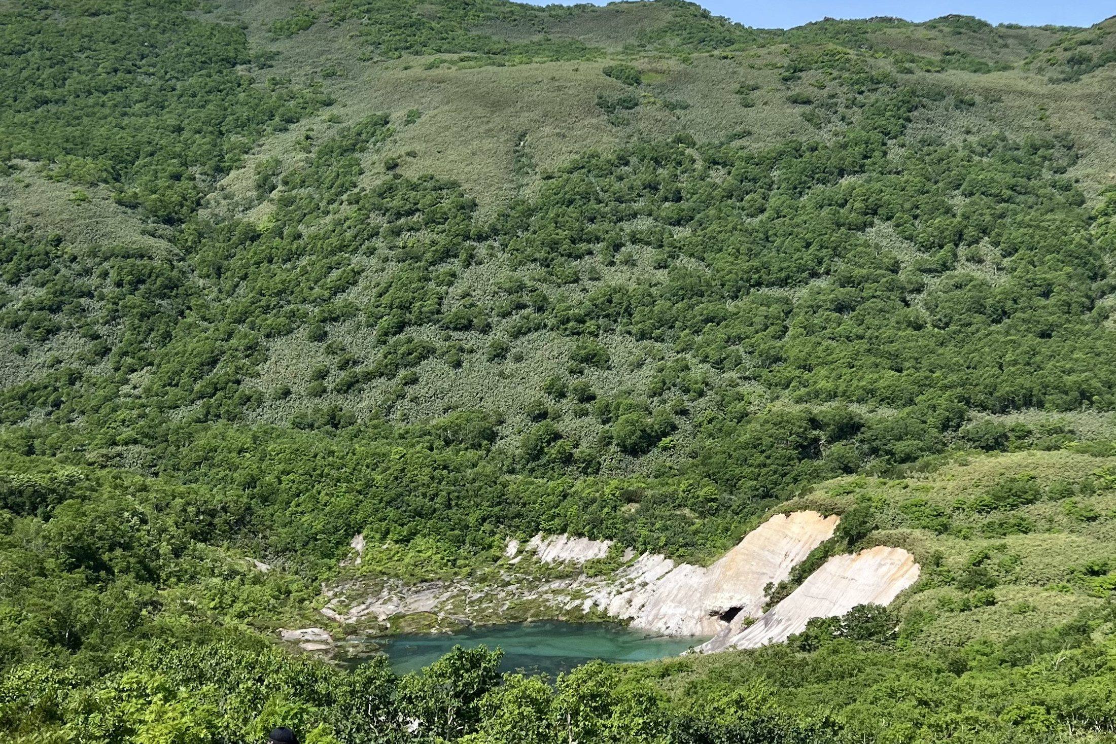 The old mine pond below the green slopes of Iwao-nupuri